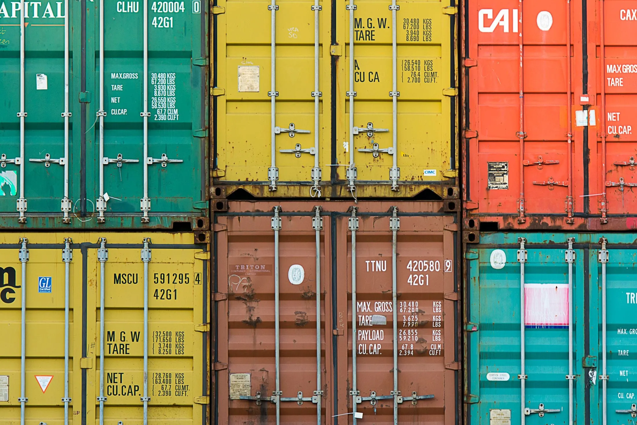 Stacked shipping containers in green, yellow and brown