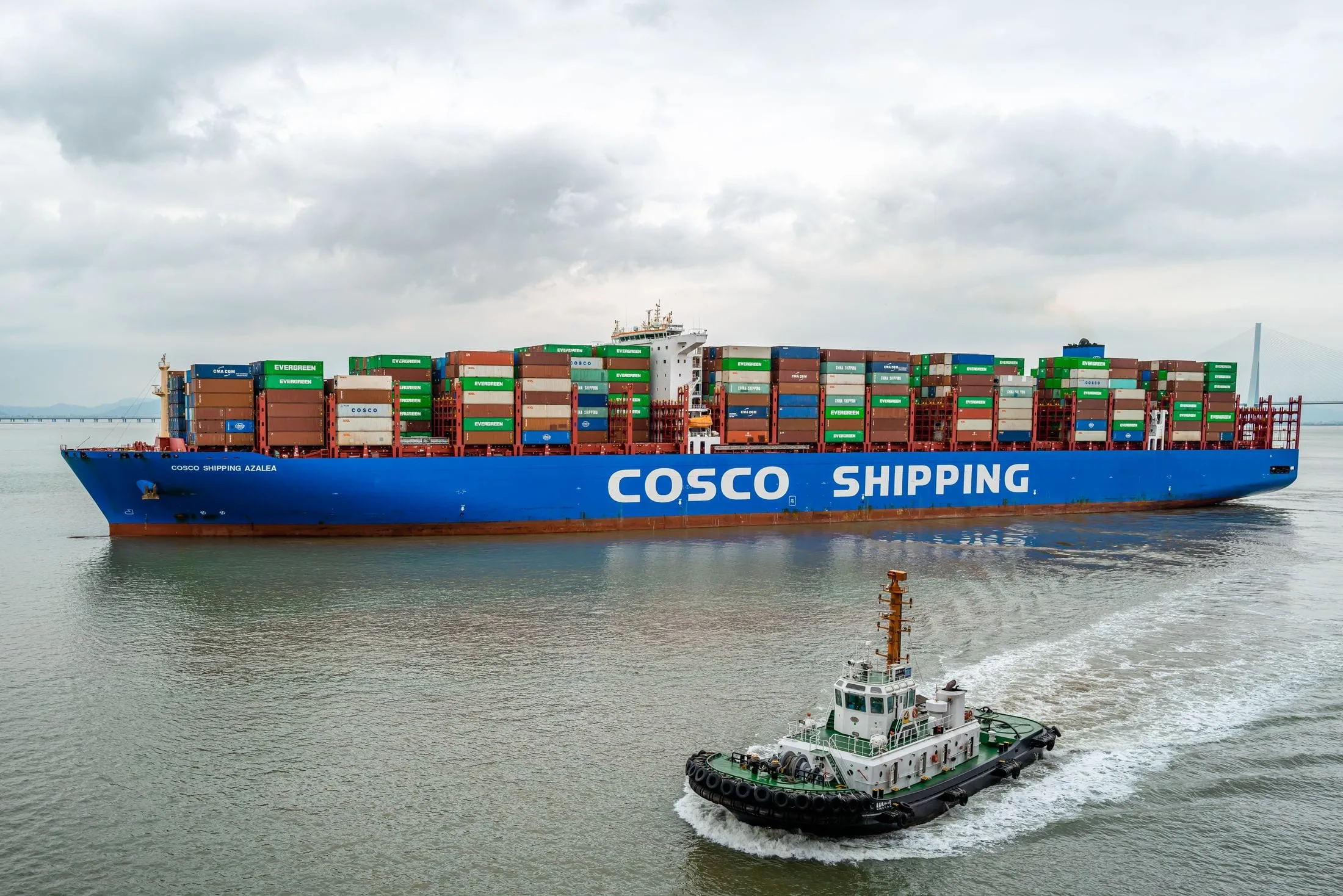 A COSCO SHIPPING container ship with a tug alongside in Ningbo harbour