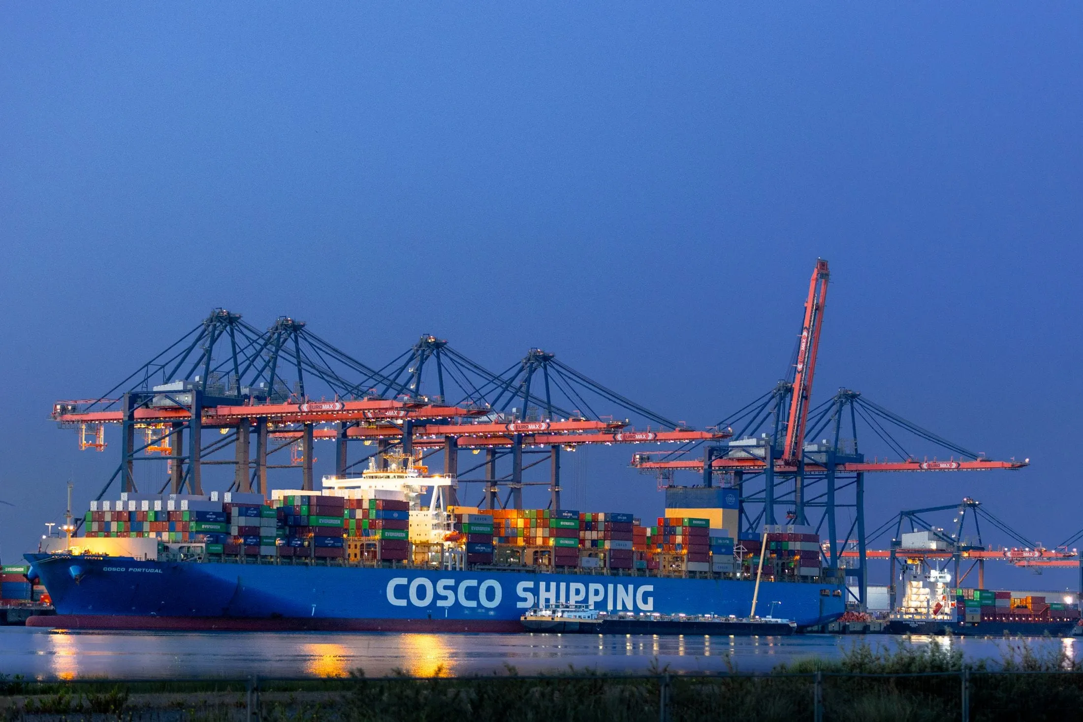 A COSCO SHIPPING vessel lit up at night at the Maasvlakte terminal, Rotterdam