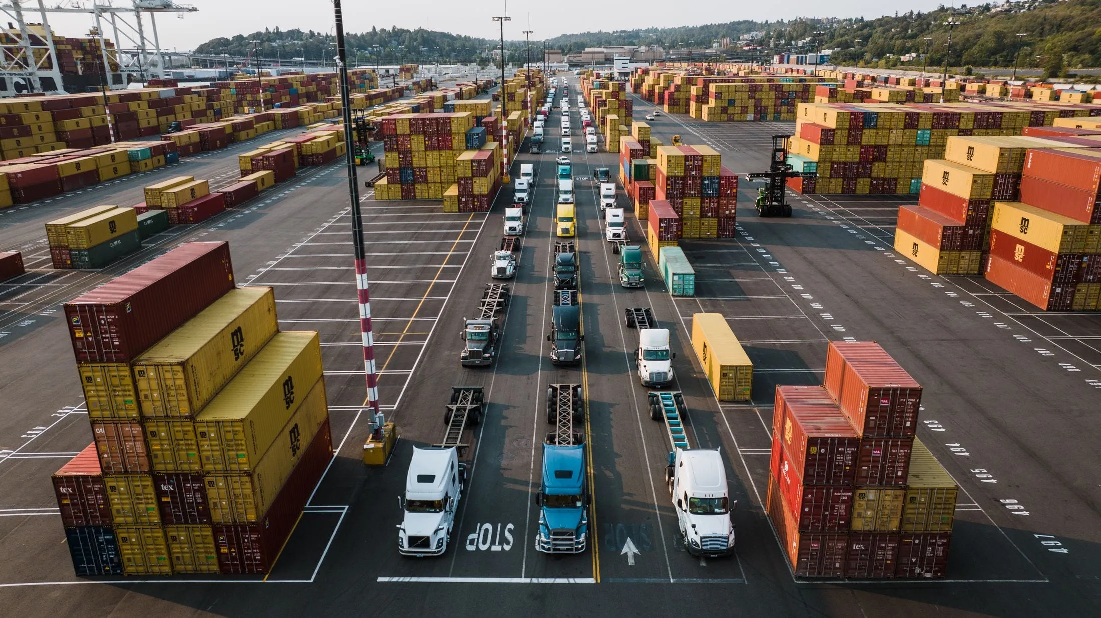 Trucks queueing between container stacks at a busy port